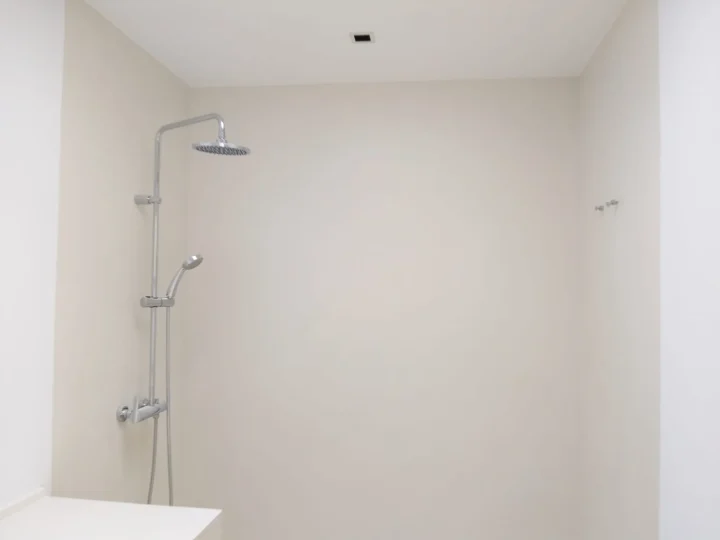 Baño reformado por completo con acabado liso de microcemento
