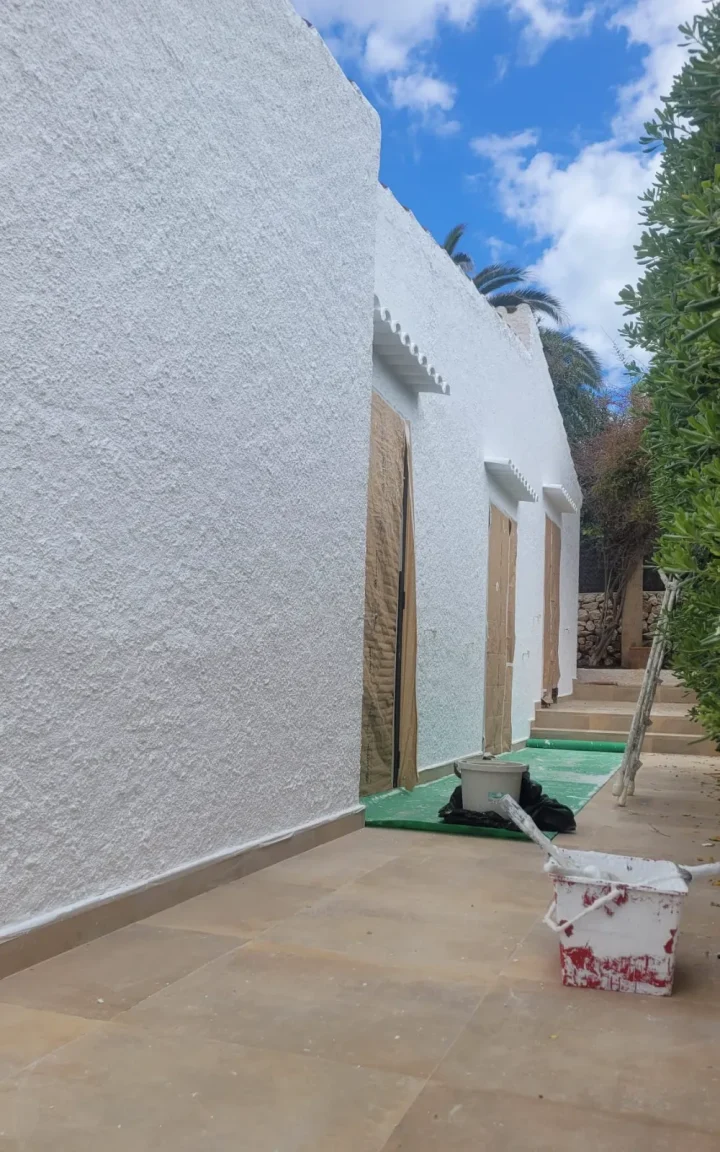 Fachada exterior pintada en blanco cal con acabado rugoso en una vivienda de Menorca