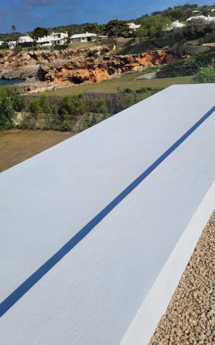 Pretil de azotea pintado en blanco con vistas a la costa de Menorca